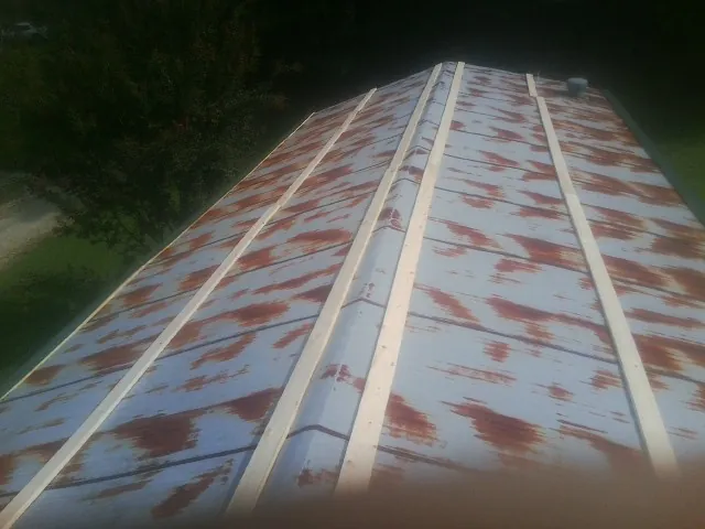 Rusted metal roof panels with new wood purlins before replacement — Storm Damage Roof Repair in Southbridge by Roofing Brothers