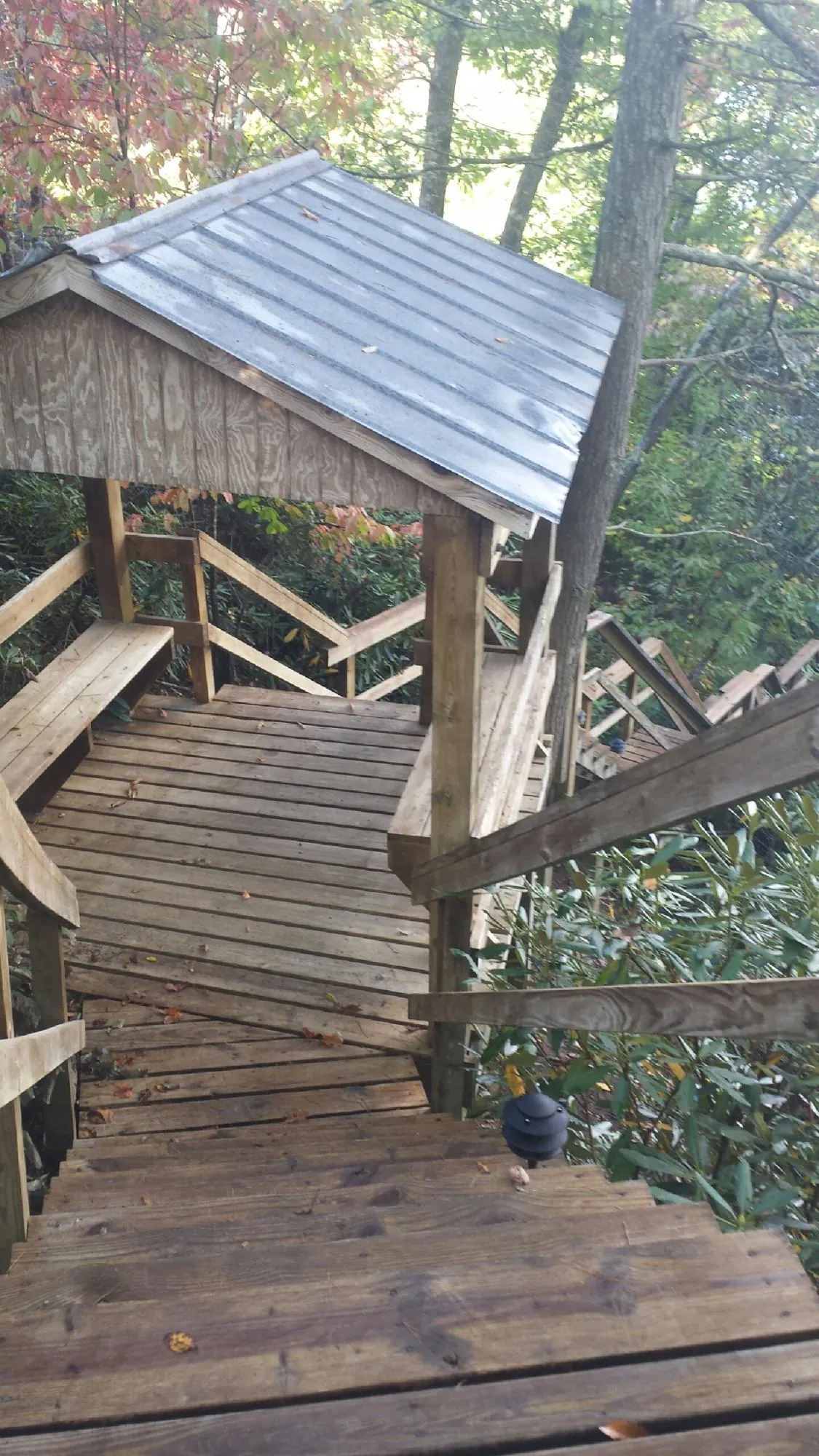 Metal roofed shelter over wooden steps on a wooded walkway — Skylight Repair & Installation work by our crew in Southbridge