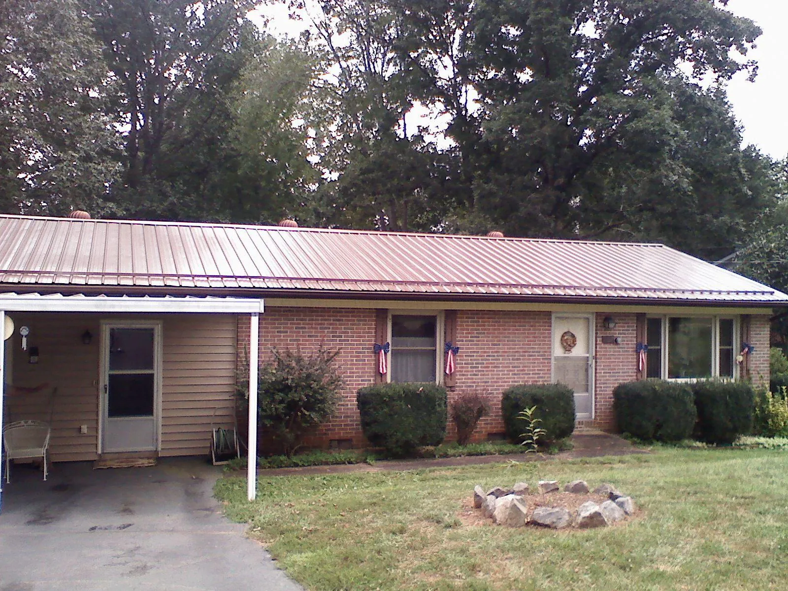 Bronze metal roof and carport on a brick ranch home — Roof Repair work by our crew in Southbridge